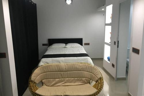 un dormitorio con una cama y una silla en Studio GARAGE, en Mindelo