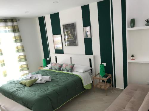 a bedroom with green and white stripes on the wall at centruMassimo b&b in Palermo