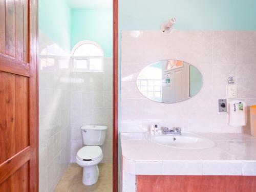 a bathroom with a sink and a toilet and a mirror at Hotel Hacienda Bacalar in Bacalar