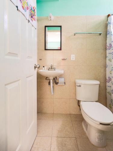 a bathroom with a toilet and a sink at Hotel Hacienda Bacalar in Bacalar