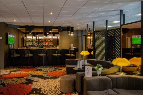 a lobby with couches and a bar in a hotel at Oceania Quimper in Quimper