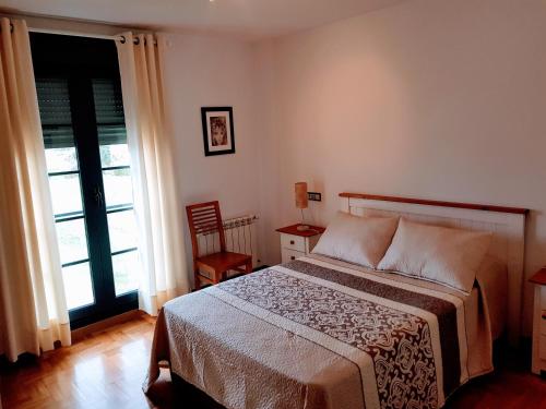 a bedroom with a bed and a large window at COMSEREX-ASTURIAS in Castropol