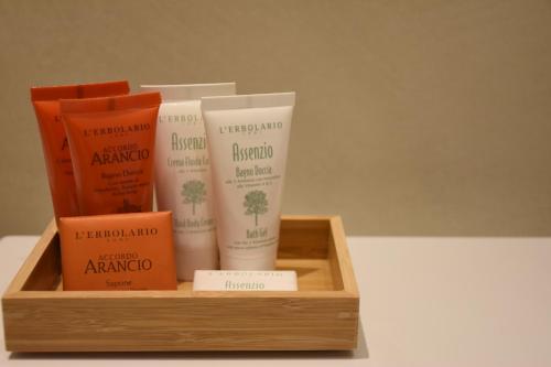 a wooden box with four bottles of shampoo and aicrobialicrobialicrobialicrobialicrobial at Garibaldi23 Rooms in La Spezia
