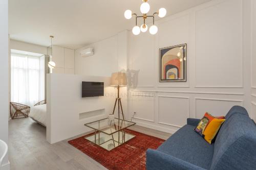 a living room with a blue couch and a tv at Morgan-Jupiter Apartments in Lisbon