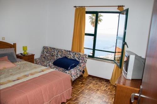 a bedroom with a bed and a window with a view at A Slice of Paradise - Palheiro Golf in Funchal