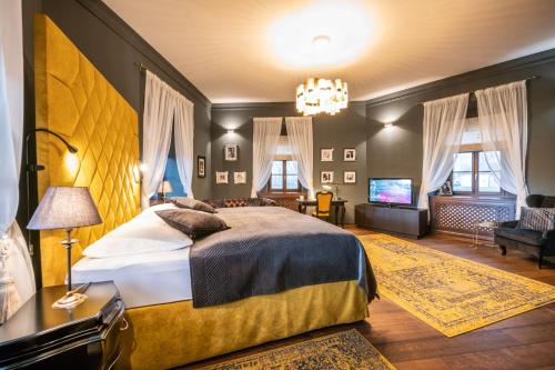 a bedroom with a large bed and a chandelier at Chateau Appony in Oponice
