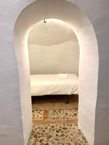 an archway with a bed in a room at Casa Cueva Castillo in Perales de Tajuña