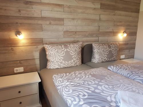 a bedroom with two beds and a wooden wall at Flensburg Ferienwohnungen Apartment 1 in Flensburg