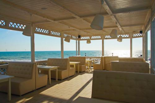 a restaurant on the beach with the ocean in the background at Hotel Paradise Beach in Alakhadzi