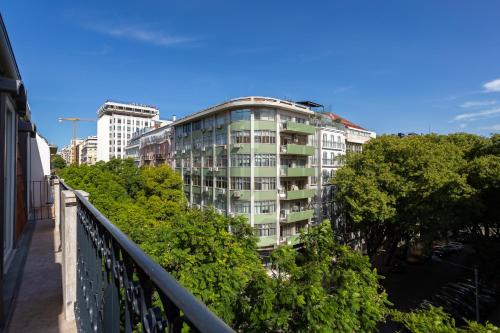 um edifício alto e branco com árvores em frente em Morgan-Jupiter Apartments em Lisboa