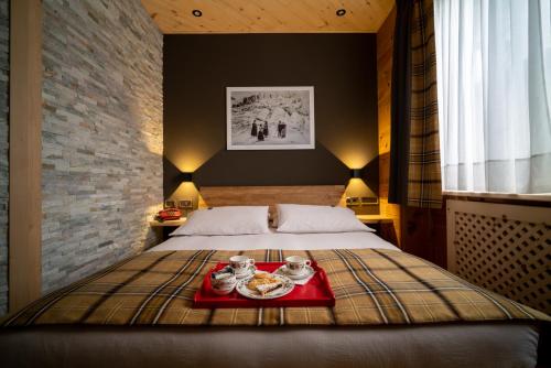 a bedroom with a bed with a tray of food on it at Meublè Garnì Della Contea in Bormio