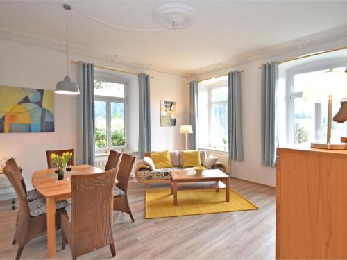 a living room with a couch and a table at Apartment in a villa with garden in Borstendorf in Wünschendorf