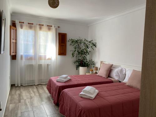 two beds in a white room with red sheets at Zankueta Etxea in Délica