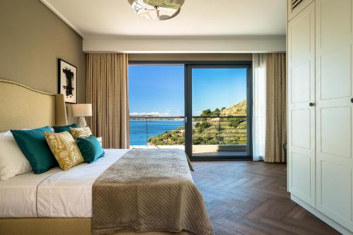 a bedroom with a bed with a view of the ocean at Melina Apartments Sea View in Argostoli