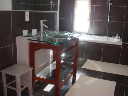 baño con lavabo de cristal y taburete en Gîte La Rosa, en Ornans