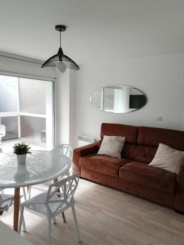 un salon avec un canapé et une table dans l'établissement Le Saint Amand, studio cabine, agréable terrasse sud, à Le Touquet-Paris-Plage