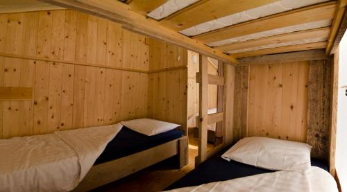 ポレッチにあるDrago Tours LODGE TENT Holiday Deluxe, Lanternaのベッド2台 木製の壁の部屋