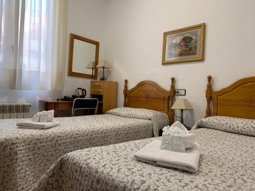 a hotel room with two beds with towels on them at Hostal Internacional in Madrid