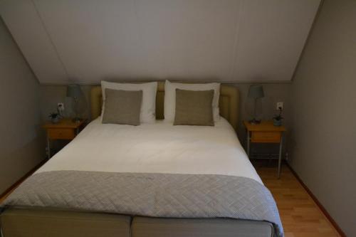 1 dormitorio con 1 cama grande y 2 mesitas de noche en B&BBolwerk, en Venray