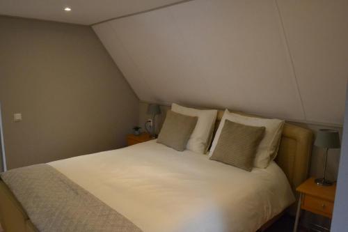 a bedroom with a bed with white sheets and pillows at B&BBolwerk in Venray
