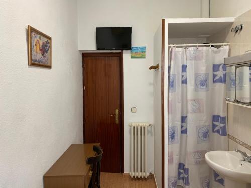 a bathroom with a sink and a shower curtain at Hostal Internacional in Madrid