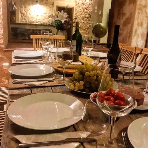 a table with wine glasses and a plate of grapes at CAL PUIG, ENOTURISMO RURAL entre Viñas y Bosques in Juncosa