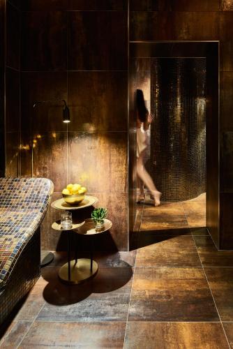 Una mujer caminando en una ducha en un baño en Hotel Savoy, en Opatija