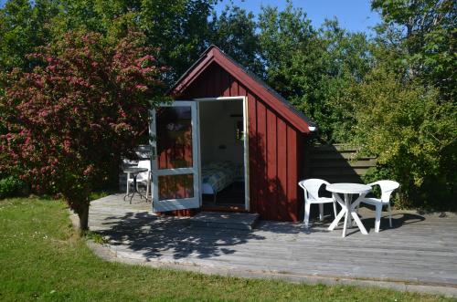 a red shed with a table and chairs on a deck at Klitgaarden in Hjørring
