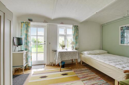 1 dormitorio con cama, mesa y ventana en Klitgaarden en Hjørring