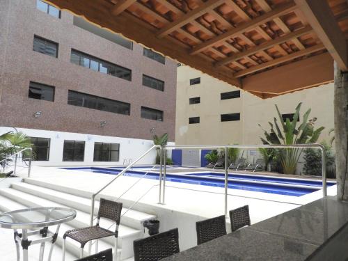 - une vue sur la piscine depuis le balcon d'un bâtiment dans l'établissement 6 Flats Capitania Varan, Pitangueiras, wifi, à Guarujá