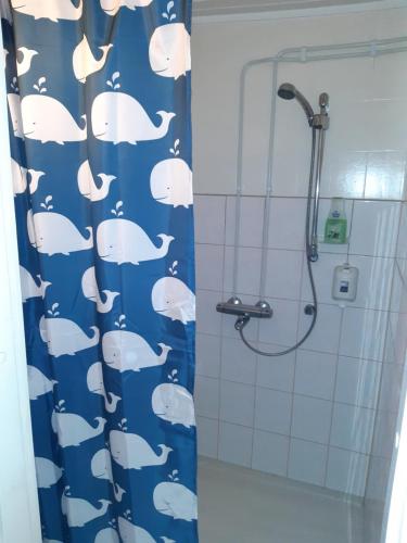 a bathroom with a blue shark shower curtain at Matkakoti, Motel Kieppi Kuhmo in Kuhmo