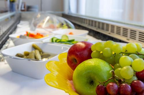 a bowl of apples and grapes on a counter at Trip Inn Kongresshotel Frankfurt-Rodgau in Rodgau