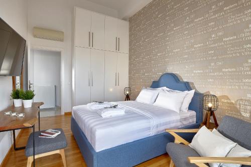 a bedroom with a blue bed and a table and a chair at Spacious Mint Luxury Villa access to Private Beach in Agia Pelagia