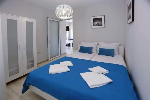 a large blue and white bed in a room at Lovely Sunrise - първа линия морска градина in Burgas City