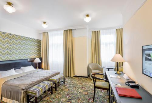 Pokój hotelowy z łóżkiem i biurkiem w obiekcie Hotel Savoy Prague w Pradze