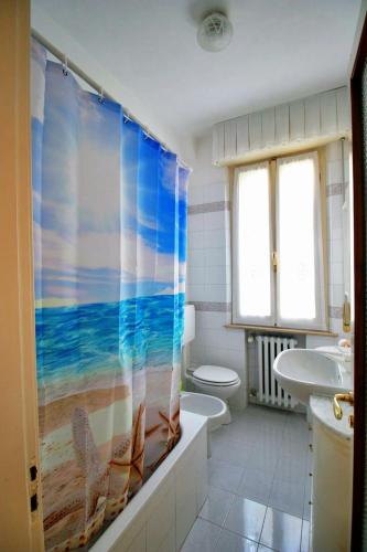 a bathroom with a shower curtain with a beach at Residenza Parco Ducale in Parma