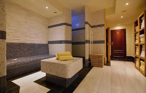 a bathroom with a tub with a yellow seat in it at Parkhotel Brno in Brno