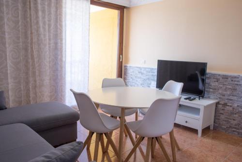 a living room with a table and chairs and a tv at Copacabana 8 in Playa Fañabe
