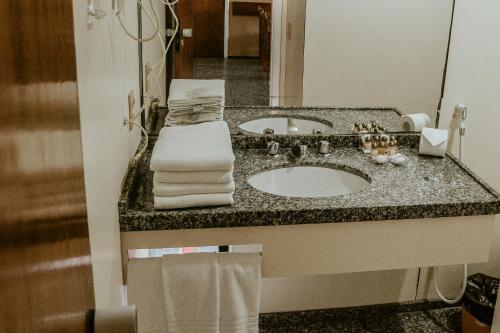 a bathroom with a sink and a mirror at Iracema Residence Hotel Flat in Fortaleza