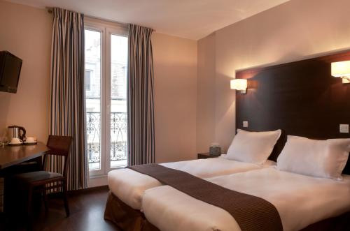 pokój hotelowy z dużym łóżkiem i oknem w obiekcie Verlain w Paryżu