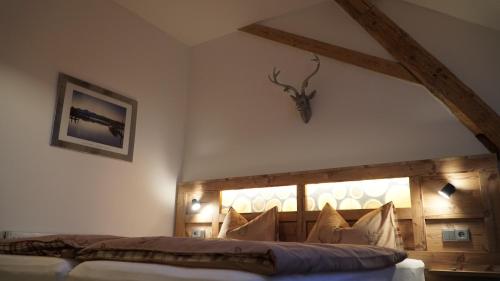 a bedroom with a bed with a wooden headboard at Gasthof/ Pension Renner in Thalmassing