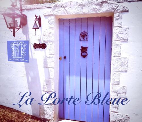 a blue door on the side of a white building at La Porte Bleue : Guest house Cosy & Jaccuzi in Saint-Pierre