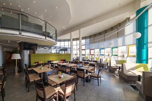 a dining room with tables and chairs in a restaurant at LifeHotel Vienna Airport in Fischamend Dorf