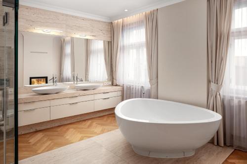 ein Badezimmer mit zwei Waschbecken und einer großen Badewanne in der Unterkunft Revolucni Apartments Old Town in Prag