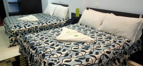 2 łóżka z czarno-białą pościelą w pokoju w obiekcie Hotel Barbareek w mieście Shillong