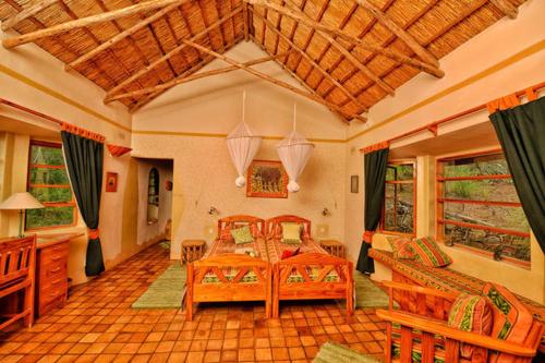 1 Schlafzimmer mit 2 Betten, einem Tisch und Stühlen in der Unterkunft Musangano Lodge in Odzi