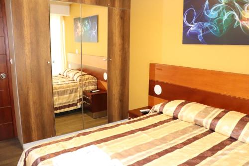 a bedroom with a bed and a mirror at Residencial Cafferata in Lima