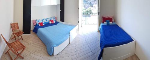 a bedroom with two twin beds and a chair at Cetara on the sea in Cetara