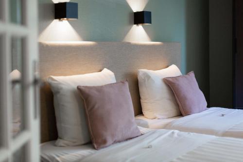a white bed with two pillows on top of it at Strandhotel Scheveningen in Scheveningen