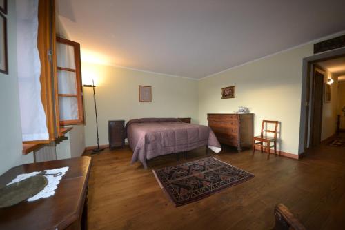 a bedroom with a bed and a dresser and a table at alla piana in Varallo